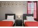 This twin bedroom features Mickey Mouse wall decals, red bedding, and a nightstand at 8942 Cabot Cliffs Dr, Davenport, FL 33896