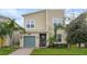 Two-story home with teal garage door, landscaped yard, and palm trees at 8942 Cabot Cliffs Dr, Davenport, FL 33896