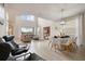 Open-concept living and dining area with high ceilings, large windows, and modern furniture at 8942 Cabot Cliffs Dr, Davenport, FL 33896