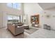 Living room with gray sectional sofa, ottoman, large windows, and entertainment center at 8942 Cabot Cliffs Dr, Davenport, FL 33896