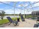 Patio with lounge chairs, grill, and a serene view of the lake at 8942 Cabot Cliffs Dr, Davenport, FL 33896