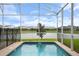 Screened pool with a safety fence and tranquil water view at 8942 Cabot Cliffs Dr, Davenport, FL 33896