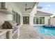 Outdoor kitchen with stainless steel appliances and a built-in grill at 104 Hampton Loop, Davenport, FL 33837