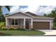 One-story home with gray siding, brown garage door, and stone accents at 1104 Patriot Loop, Haines City, FL 33844