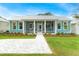 Charming light teal cottage with metal roof, screened porch, and paved walkway at 12071 Lakeshore Way, Oxford, FL 34484