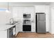 Modern kitchen with white cabinets and stainless steel appliances at 12071 Lakeshore Way, Oxford, FL 34484