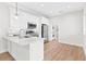 White kitchen with stainless steel appliances and laundry access at 12071 Lakeshore Way, Oxford, FL 34484