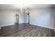 Main bedroom with dark wood-look floors, a modern chandelier, and an arched doorway at 126 Whitby St, Davenport, FL 33897