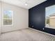 Spacious bedroom with dark blue accent wall and grey carpet at 1515 Cedar Lake Dr, Orlando, FL 32824