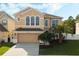 Two-story house with tan exterior, three-car garage, and palm trees at 1515 Cedar Lake Dr, Orlando, FL 32824