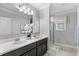 Modern bathroom with double vanity, walk-in shower, and gray tile flooring at 2069 Canton Park Dr, Winter Haven, FL 33881