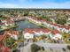 Scenic aerial view of a community with a pond and fountains at 2504 Woodgate Blvd # 107, Orlando, FL 32822