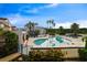 Community pool surrounded by palm trees and lounge chairs at 2504 Woodgate Blvd # 107, Orlando, FL 32822