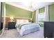 Green bedroom with a king-size bed, nightstands, and modern decor at 2901 Edenshire Way # 104, Kissimmee, FL 34746