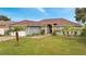 Single-story house with a brown roof, attached garage, and palm trees in the front yard at 405 Mallard Ln, Kissimmee, FL 34759