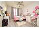 Spacious bedroom with a pink bed frame, built-in desk, and a large window at 5427 Hanover Square Dr, St Cloud, FL 34771