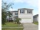 Two-story house with gray siding, white trim, and a two-car garage at 5427 Hanover Square Dr, St Cloud, FL 34771