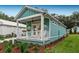 Side view of teal cottage showcasing landscaping and lawn at 12133 Grand Oak Ln, Oxford, FL 34484