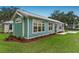 Single-story home with metal roof and light blue siding at 12133 Grand Oak Ln, Oxford, FL 34484