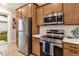 Modern kitchen features stainless steel appliances and light wood cabinets at 12133 Grand Oak Ln, Oxford, FL 34484