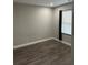 Empty bedroom with dark wood-look laminate floors and a window with black curtains at 1704 Osceola Park Dr, Kissimmee, FL 34741