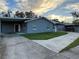 Front exterior of a single-story home with a gray facade, attached garage, and concrete driveway at 1704 Osceola Park Dr, Kissimmee, FL 34741