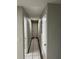 Hallway with tile and wood-look laminate flooring, white doors, and light gray walls at 1704 Osceola Park Dr, Kissimmee, FL 34741