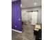 Hallway or entryway with a purple accent wall, sliding barn door, and wood-look laminate floors at 1704 Osceola Park Dr, Kissimmee, FL 34741