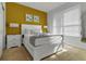 Bedroom with mustard yellow accent wall and white furniture at 17417 Placidity Ave, Clermont, FL 34714