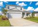 Two-story house with gray siding, two-car garage, and landscaped yard at 381 Citrine Loop, Kissimmee, FL 34758