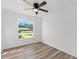 Bright bedroom with large window, ceiling fan and wood-look floors at 2588 Sun Acres Blvd, Auburndale, FL 33823