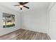 Well-lit bedroom featuring wood-look floors and backyard view at 2588 Sun Acres Blvd, Auburndale, FL 33823