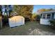 White shed and home exterior in backyard setting at 26221 Se 159Th Ln, Umatilla, FL 32784