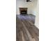 Spacious living room with brick fireplace and wood-look flooring at 26221 Se 159Th Ln, Umatilla, FL 32784