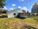 Home's back exterior showcases a screened porch and a large yard at 3334 Mount Tabor Rd, Lakeland, FL 33810