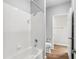 Bright bathroom featuring white tile, bathtub, toilet, and open door to closet at 3725 Conroy Rd # 2131, Orlando, FL 32839