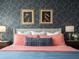 Bedroom with coral bedding, geometric wallpaper, and framed art at 8933 Amelia Downs Trl, Kissimmee, FL 34747