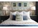 Well-lit bedroom featuring geometric wallpaper and comfortable bedding at 8933 Amelia Downs Trl, Kissimmee, FL 34747