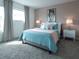 Spacious bedroom with Audrey Hepburn art and teal bedding at 8933 Amelia Downs Trl, Kissimmee, FL 34747