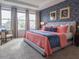 Spacious bedroom with coral bedding, and geometric accent wall at 8933 Amelia Downs Trl, Kissimmee, FL 34747