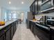 Modern kitchen boasts dark cabinetry, stainless steel appliances, and granite countertops at 8933 Amelia Downs Trl, Kissimmee, FL 34747