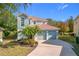 Two-story house with two-car garage, landscaping, and a palm tree at 944 Torrey Pine Dr, Winter Springs, FL 32708