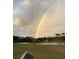 Double rainbow over a lush green golf course with a pond and residential homes at 944 Torrey Pine Dr, Winter Springs, FL 32708