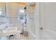 Clean bathroom with white tile, pedestal sink, and tub at 1217 Magnolia Ave, Sanford, FL 32771