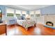 Bedroom with hardwood floors, white metal bed frame, and fireplace at 1217 Magnolia Ave, Sanford, FL 32771