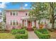 Charming pink house with white trim, manicured landscaping, and a welcoming front porch at 1217 Magnolia Ave, Sanford, FL 32771