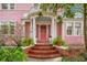 Brick steps leading to a beautiful pink front door with a columned portico at 1217 Magnolia Ave, Sanford, FL 32771