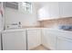 Laundry room with white cabinets, a utility sink, and tile flooring at 1217 Magnolia Ave, Sanford, FL 32771