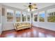 Sunroom with hardwood floors, multiple windows, and a comfy couch at 1217 Magnolia Ave, Sanford, FL 32771