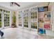 Sunroom with French doors, hardwood floors, and built-in shelving at 1217 Magnolia Ave, Sanford, FL 32771